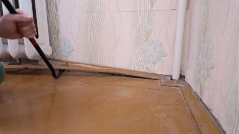 Prying Up Baseboard Next To Radiator Pipes During Renovation Process Stock Footage 328521702