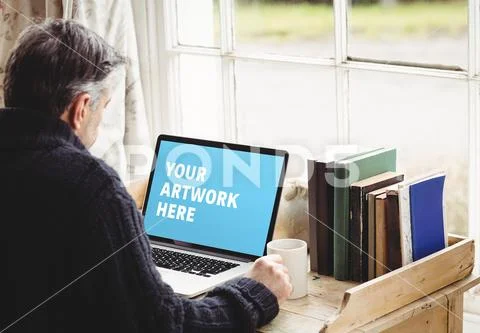 PSD template of active senior man using laptop at desk in home PSD Template