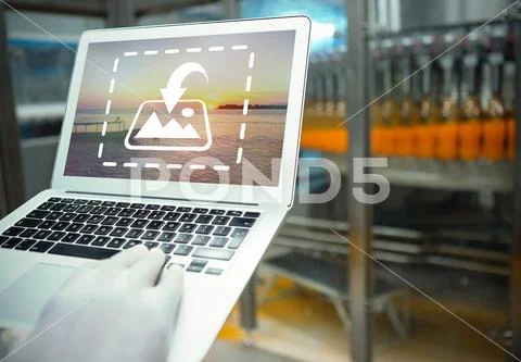PSD template of cropped hand of worker using laptop in juice factory PSD Template