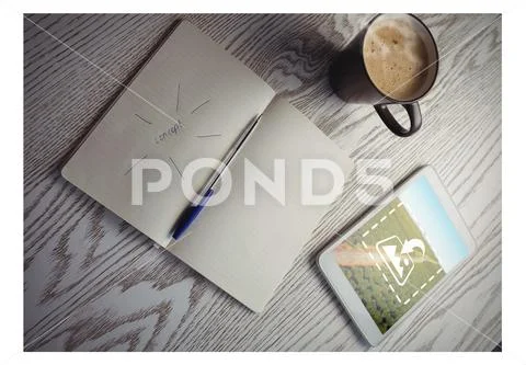 PSD template of digital tablet, coffee mug and notepad with pen on wooden table PSD Template