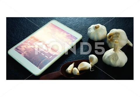 PSD template of garlic and digital tablet on black background PSD Template