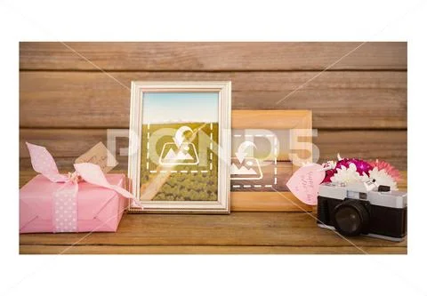 PSD template of gift box, photo frame and vintage camera on wooden plank PSD Template