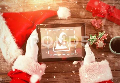 PSD template of Hand of Santa Claus using digital tablet on wooden table Modello PSD