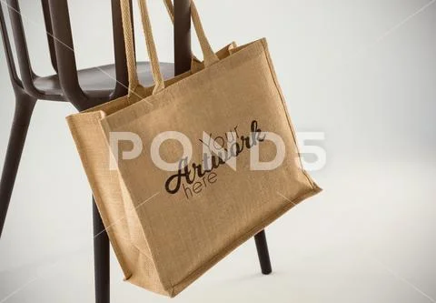 PSD template of jute bag hanging on a black chair against white background PSD Template