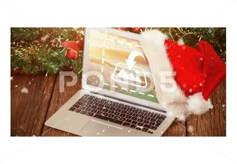 PSD template of laptop with Santa hat and Christmas tree on wooden table PSD Template