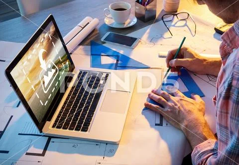 PSD template of male architect working on blueprint with laptop at desk in PSD Template