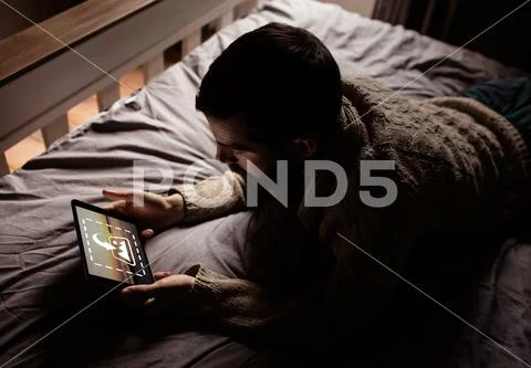 PSD template of man using digital tablet on bed in bedroom at home Modello PSD