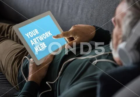 PSD template of man using digital tablet on sofa PSD Template