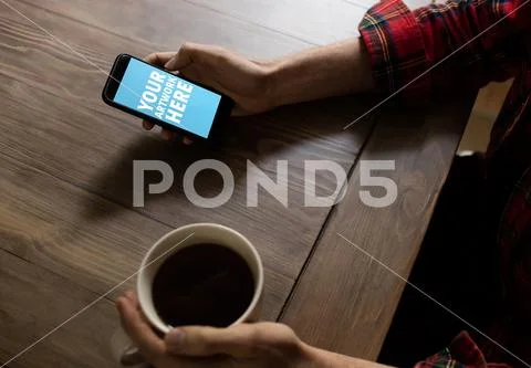 PSD template of man using mobile phone while having coffee at table in home PSD Template