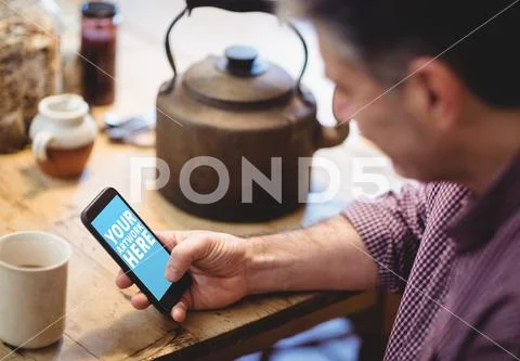 PSD template of man using mobile phone at dining table in home PSD Template