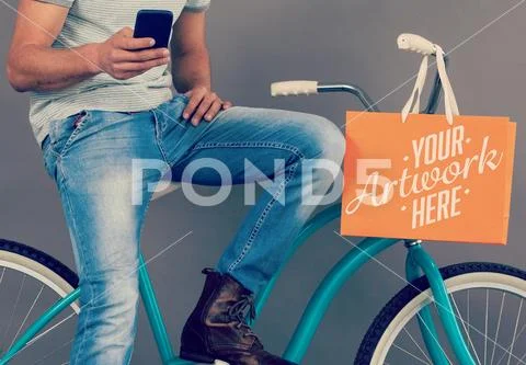 PSD template of man using mobile phone with shopping bag hanging on bicycle PSD Template