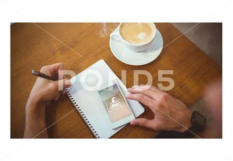 PSD template of man writing on notepad while using mobile phone in cafe PSD Template