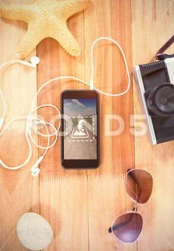 PSD template of mobile phone and beach accessories on wooden table PSD Template