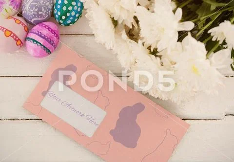 PSD template of multicolored Easter eggs, bunch of flower and envelope on wooden PSD Template