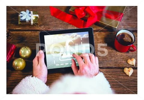 PSD template of Santa hand using digital tablet at wooden table during Christmas PSD Template