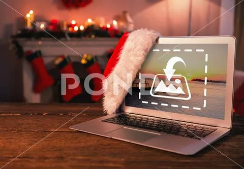 PSD template of Santa hat hanging on laptop on wooden table at home PSD Template