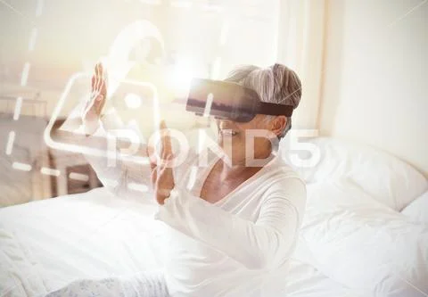 PSD template of senior woman using virtual headset on bed in bedroom PSD Template