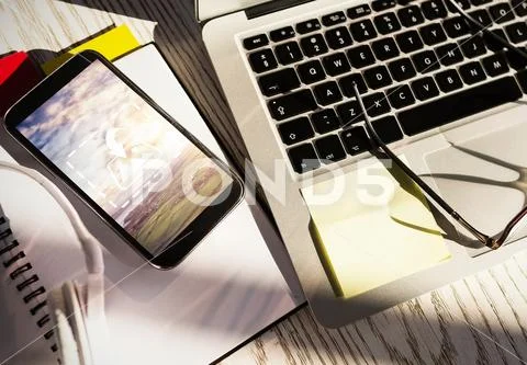 PSD template of wireless devices, eyeglasses and stationery on wooden table PSD Template