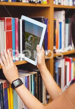 PSD template of woman keeping digital tablet in bookshelf at library PSD Template