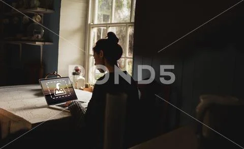 PSD template of woman using laptop at dining table in home PSD Template