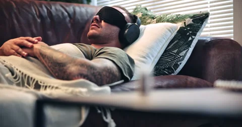 Psychedelic, appointment and man with headphones on sofa, blindfold therapy or Stock Footage 331452958