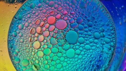 Psychedelic colorful oil bubbles floating in water Stock Footage 321660921