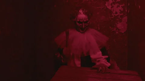Psycho in Costume of Clown Hitting Table with Axe in Red Light Stock Footage 250959890