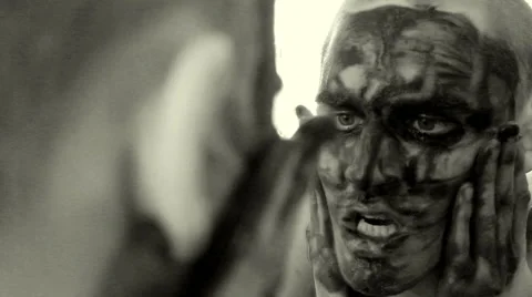 Psycho guy with painted face in front of the mirror Stock Footage 48861397