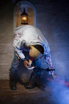 Psycho, Man chained with blood and knife, has a severed leg blood Stock Photos