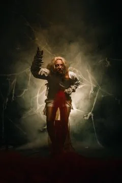A psycho in a straitjacket vomits on a black background in the Studio Foto stock