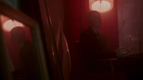 Psycho Writing something under red light with his reflection Vídeo Stock 259851659