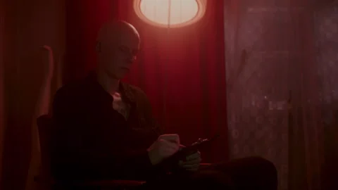 Psycho Writing something under red light Vídeo Stock 259851944