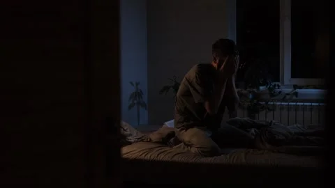 Psychological disorders and problems. Silhouette of a man sitting on the edge of Video stock 296424730