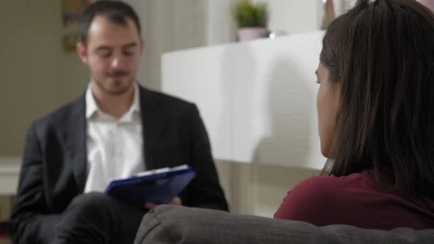 Psychologist listening and taking notes during session with female patient Video stock 108389010