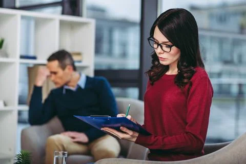 Psychologist making notes in document Stock Photos