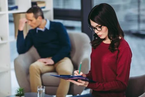 Psychologist making notes in document Stock Photos