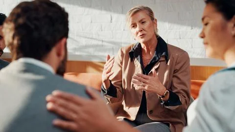 Psychologist, support and therapy session with group in office, talk or employee Stock Photos