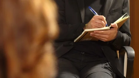 Psychologist takes notes during the session with the patient Stock Footage 85831129