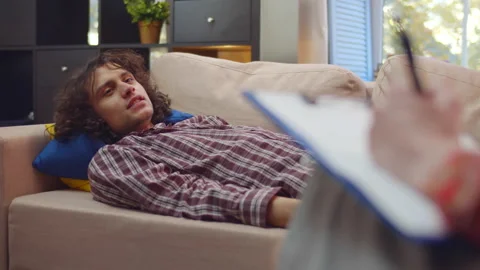 Psychologist taking notes on clipboard and listens client at psychotherapy Stock-Footage 220549751