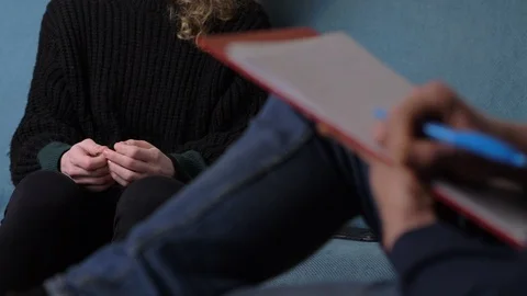 Psychologist taking notes during session with anxious female patient Stock Footage 103583855