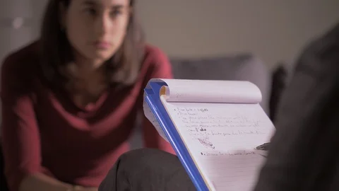Psychologist taking notes during session with his female patient-close up Stock-Footage 105010830