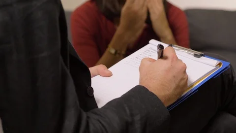 Psychologist taking notes during therapeutic session-close up Stock Footage 100035008