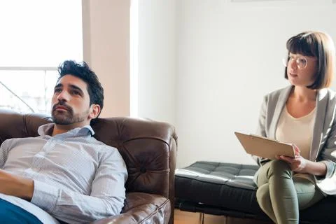Psychologist taking notes during therapy session. Stock Photos