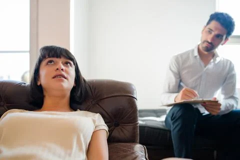 Psychologist taking notes during therapy session. Stock Photos