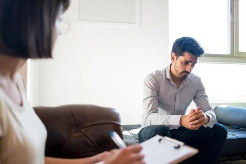 Psychologist taking notes during therapy session. Stock Photos