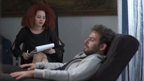 Psychologist talks to the patient lying on the couch Video stock 71037650