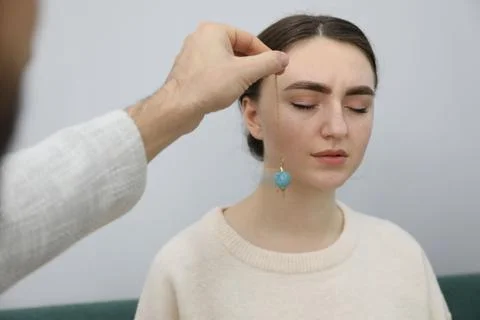 Psychologist using pendulum while working with patient during hypnosis sess.. Stock Photos