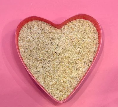 Psyllium in the shape of a heart on a pink background, top view. Super food Stock Photos