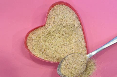 Psyllium in the shape of a heart on a pink background, top view. Super food Stock Photos