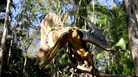 Pterodactyl Dinosaur Statue Perched on a Branch in a Lush Forest Stock Footage 331764886